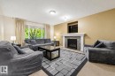Living area with a built-in electric fireplace featuring a stone surround and a white mantel - 1804 121 Street, Edmonton, AB 