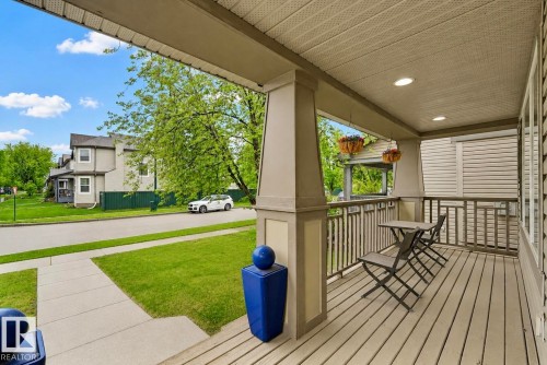 Covered front porch featuring a wood-finish floor, recessed lighting, and a painted railing - 1804 121 Street, Edmonton, AB 