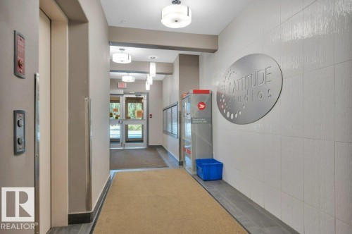 Modern building entry featuring an elevator, glass-paneled entry doors, recessed lighting, wall-mounted mailboxes, and a textured wall finish - 140 308 Ambleside Link Link, Edmonton, AB 
