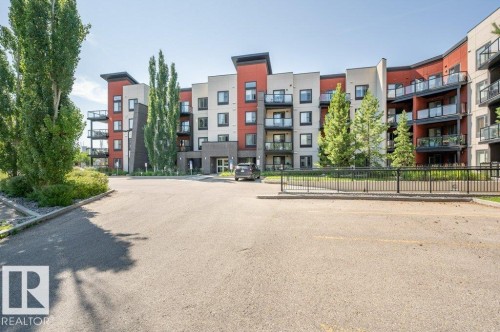 Modern multi-story building featuring a red and white facade - 140 308 Ambleside Link Link, Edmonton, AB 