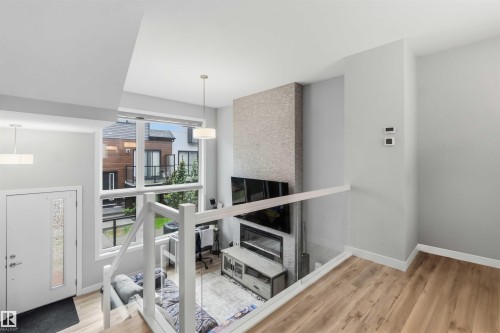 Two-story living area featuring a full-height stone-look fireplace surround with an electric insert - 33 1729 Keene Crescent, Edmonton, AB 