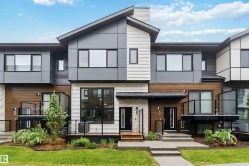 Modern townhome exterior featuring multi-textured facade with wood-look siding and horizontal panels - 33 1729 Keene Crescent, Edmonton, AB 