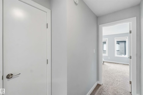 Hallway featuring light gray walls, white trim, and neutral carpeting - 33 1729 Keene Crescent, Edmonton, AB 