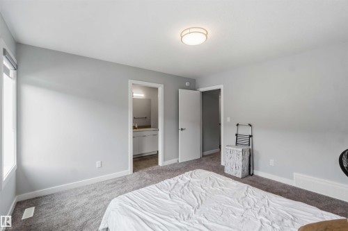 Bedroom with light gray walls, gray carpeting, and a window with a roller shade - 33 1729 Keene Crescent, Edmonton, AB 