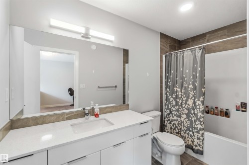 Modern bathroom featuring a single vanity with a white countertop and undermount sink - 33 1729 Keene Crescent, Edmonton, AB 