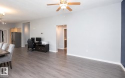 Open-concept interior featuring wood-finish flooring, a ceiling fan with integrated lighting, and recessed lighting - 