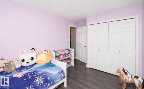 Interior room featuring wood-finish flooring, light purple wall paint, and white trim - 209 5128 Highway 18, Rural Barrhead County, AB 