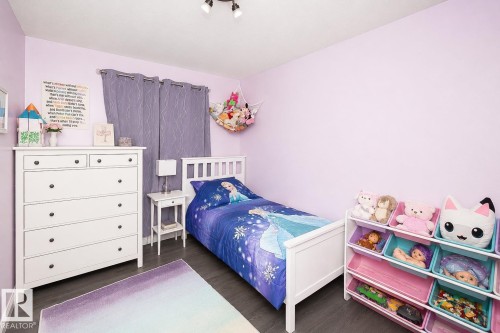 Room featuring light purple walls and wood-finish flooring - 209 5128 Highway 18, Rural Barrhead County, AB 