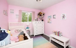 Bedroom featuring a window with exterior views, dark wood-finish flooring, and track lighting - 