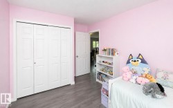 Room featuring wood-finish flooring, a bi-fold closet with panel doors, and a solid interior door with a chrome knob - 