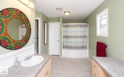 Bathroom featuring light green walls, a curved shower-tub combination, and a single window - 