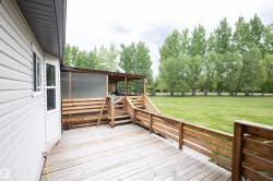 Expansive wood deck with a screened-in porch and wooden railings - 