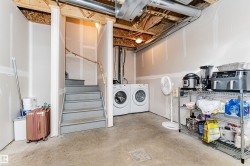 Unfinished basement space featuring a concrete floor, exposed ceiling joists, and drywall-ready walls - 