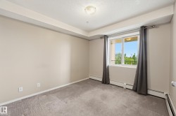 Room featuring beige walls, textured ceiling, and gray carpeted flooring - 