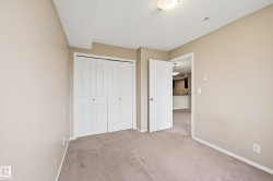 Neutral-toned walls and carpeted flooring define this room, featuring a double bi-fold closet with white paneled doors - 