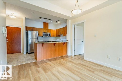 Open concept living area featuring wood-finish flooring - 409 10333 112 Street, Edmonton, AB 