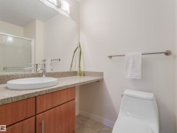 Bathroom featuring a contemporary vessel sink, chrome faucet, wood-finish vanity cabinetry, and a light-toned granite countertop - 