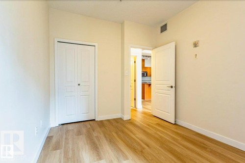 Interior space featuring wood-finish flooring and light-toned walls - 409 10333 112 Street, Edmonton, AB 