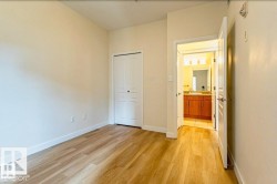 Room featuring wood-finish flooring, light-toned walls, and white baseboards - 
