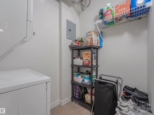 Dedicated laundry area featuring stacked white appliances - 409 10333 112 Street, Edmonton, AB 