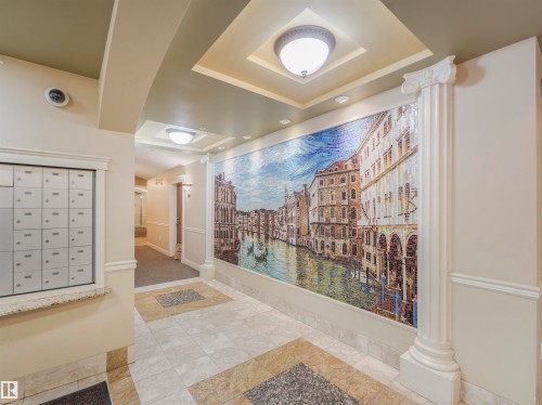Elaborate mosaic wall art featuring a cityscape, framed by a decorative column and recessed lighting - 409 10333 112 Street, Edmonton, AB 