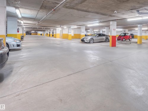 Spacious subterranean parking garage with concrete flooring and overhead fluorescent lighting - 409 10333 112 Street, Edmonton, AB 