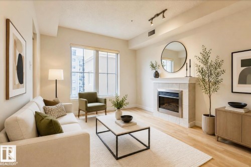 Living area featuring light wood-finish flooring and a tiled fireplace with a stainless steel insert - 409 10333 112 Street, Edmonton, AB 