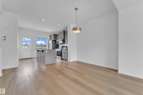 Open-concept living space featuring wood-finish flooring and abundant natural light - 1534 157 Street, Edmonton, AB 