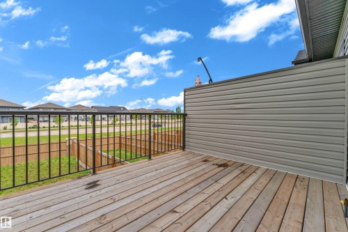 Wood-finish deck with a black metal railing and a privacy wall featuring horizontal siding - 1534 157 Street, Edmonton, AB 