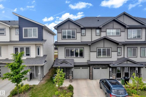 Contemporary multi-level townhome featuring a mixed-material facade with horizontal siding and stone accents - 1534 157 Street, Edmonton, AB 