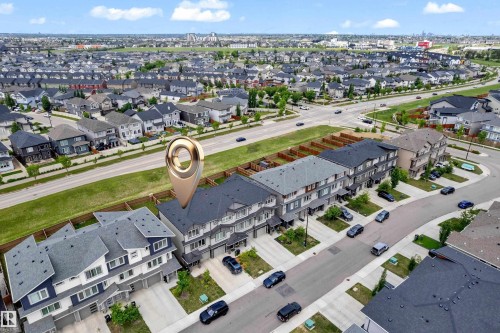 Aerial perspective of a multi-unit residential property within a developed neighborhood, featuring contemporary architectural design, paved driveways, and street parking - 1534 157 Street, Edmonton, AB 