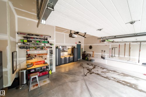 Spacious garage with exposed drywall, concrete flooring, and an integrated ceiling-mounted garage door opener system - 14508 78 Avenue, Edmonton, AB 