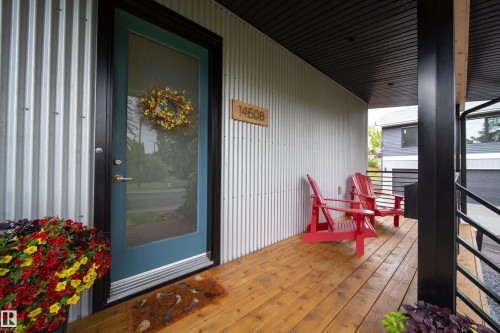 Covered porch entry featuring wood-finish flooring, corrugated metal siding, and a solid wood ceiling - 14508 78 Avenue, Edmonton, AB 