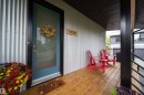 Covered porch entry featuring wood-finish flooring, corrugated metal siding, and a solid wood ceiling - 14508 78 Avenue, Edmonton, AB 