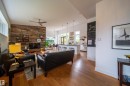 Living area featuring wood-finish flooring and a distinctive wood-paneled accent wall - 14508 78 Avenue, Edmonton, AB 