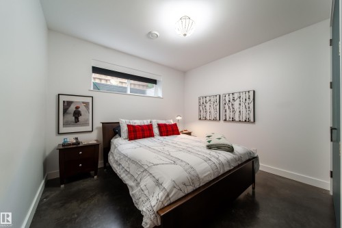 Bedroom featuring a high ceiling, polished concrete flooring, recessed lighting, and a modern ceiling light fixture - 14508 78 Avenue, Edmonton, AB 