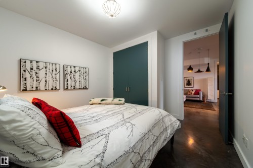 Bedroom featuring a semi-flush mount ceiling fixture and a built-in closet with dark teal doors - 14508 78 Avenue, Edmonton, AB 