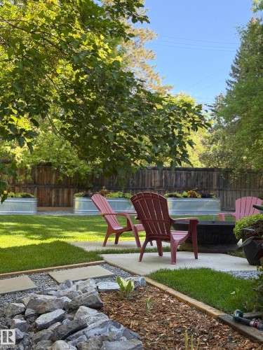 Expansive backyard featuring a manicured lawn, concrete patio areas, and a defined gravel path - 14508 78 Avenue, Edmonton, AB 