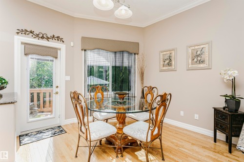 Bright dining area featuring wood-finish flooring and a full-light exterior door - 116 Darlington Crescent, Edmonton, AB 