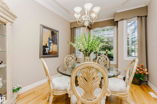 Dining area featuring a decorative chandelier, recessed ceiling design, and light wood-finish flooring - 116 Darlington Crescent, Edmonton, AB 