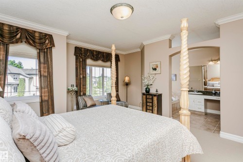Expansive bedroom featuring crown molding, multiple windows with decorative valances, and a four-poster bed frame - 116 Darlington Crescent, Edmonton, AB 