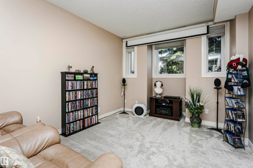 Carpeted room with multiple windows and a projector screen - 116 Darlington Crescent, Edmonton, AB 