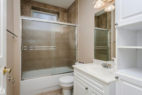 Bathroom featuring a white vanity with integrated sink, chrome faucet, and overhead lighting - 116 Darlington Crescent, Edmonton, AB 