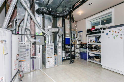 Utility area featuring two furnaces, a water heater, and exposed ductwork - 116 Darlington Crescent, Edmonton, AB 