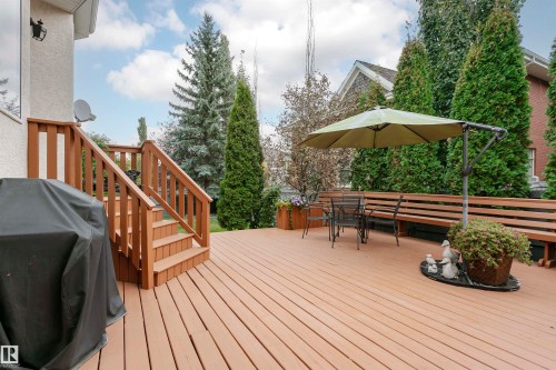 Spacious wood-finish deck with integrated perimeter seating, providing extensive outdoor entertaining space - 116 Darlington Crescent, Edmonton, AB 