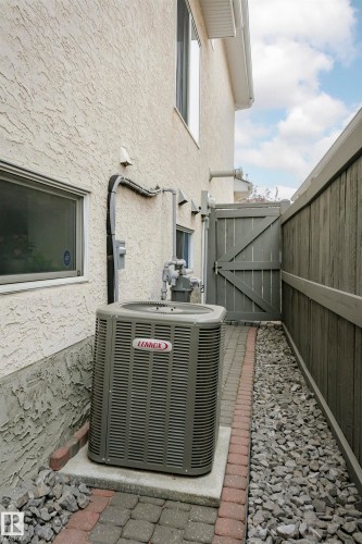 Exterior stucco siding with a Lennox air conditioning unit on a concrete pad - 116 Darlington Crescent, Edmonton, AB 