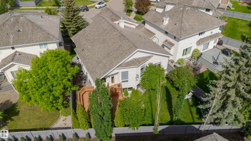 Expansive property featuring a multi-level deck, mature trees, manicured lawn, paved patio area, and privacy fencing - 116 Darlington Crescent, Edmonton, AB 