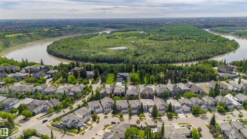 Aerial perspective showcasing a residential neighborhood bordering a substantial river and extensive green space - 116 Darlington Crescent, Edmonton, AB 