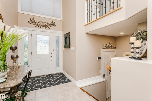 Two-story entryway featuring a decorative front door with sidelights, transom window, and tile flooring - 116 Darlington Crescent, Edmonton, AB 
