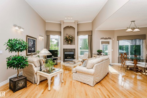 Living area featuring vaulted ceilings, light wood-finish flooring, and a fireplace with stone surround - 116 Darlington Crescent, Edmonton, AB 
